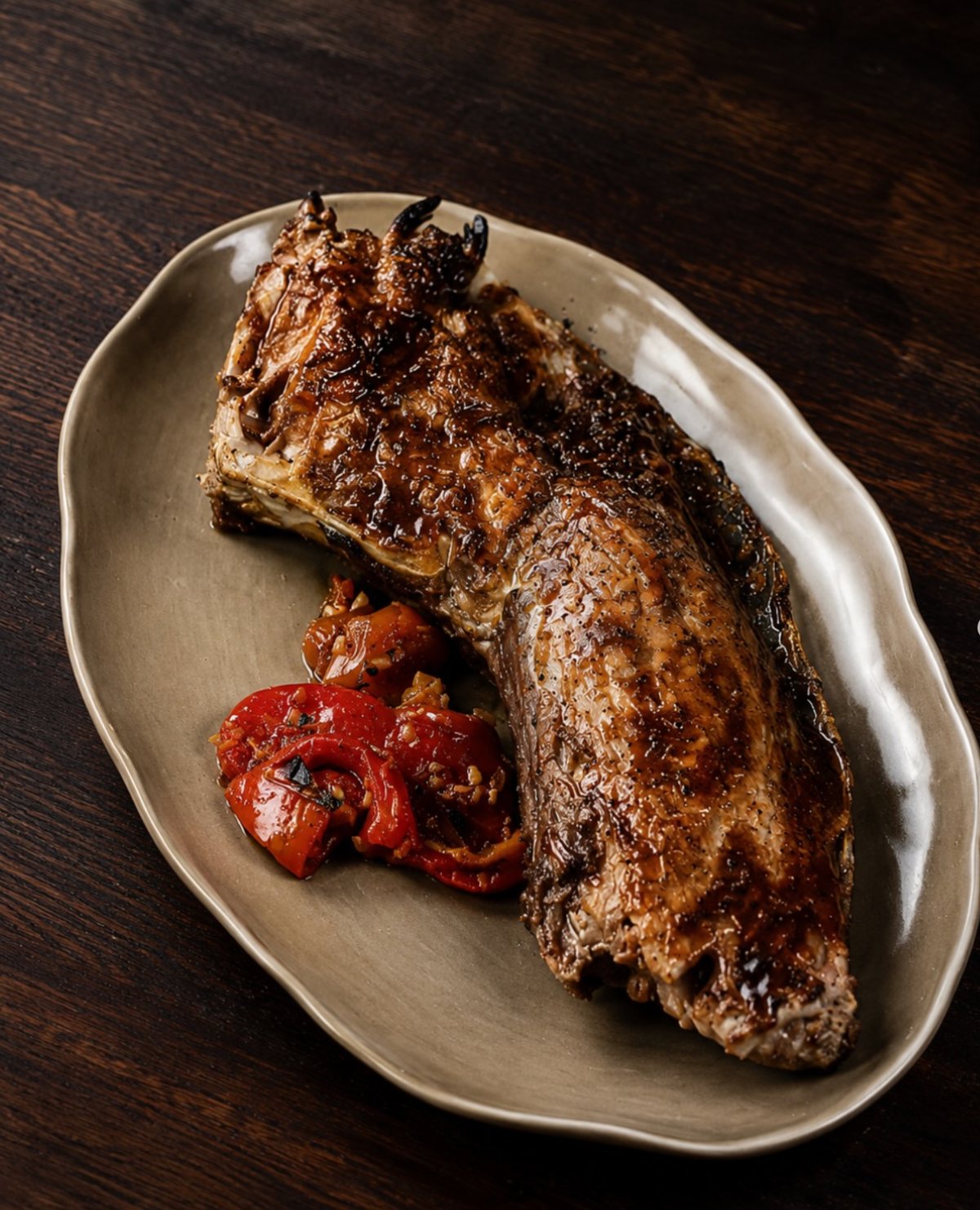 A grilled cut served with roasted peppers